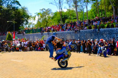 Bandung, Batı Cava, Endonezya - 17 Ağustos 2023: Endonezya 'nın 78. Bağımsızlık Günü Festivali sırasında motosiklet dublörlerinin hareketlerini izleyen heyecanlı seyirciler, eğlenceli ve ferahlatıcı bir kutlama.