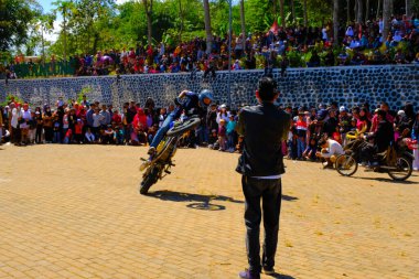Bandung, Batı Cava, Endonezya - 17 Ağustos 2023: Endonezya 'nın 78. Bağımsızlık Günü Festivali sırasında motosiklet dublörlerinin hareketlerini izleyen heyecanlı seyirciler, eğlenceli ve ferahlatıcı bir kutlama.