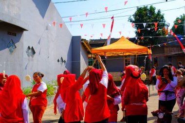 Bandung, Batı Cava, Endonezya - 17 Ağustos 2023: Endonezya 'nın 78. bağımsızlık gününü anmak için orta yaşlı kadınlar arasındaki kraker yeme yarışması, eğlenceli ve ferahlatıcı bir yarışma.
