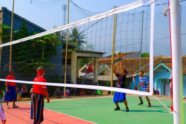 Bandung, Batı Cava, Endonezya - 17 Ağustos 2023: Bir grup orta yaşlı adam Endonezya 'nın 78. bağımsızlık günü, eğlenceli ve ferahlatıcı bir yarışma için voleybol müsabakası düzenliyorlar.