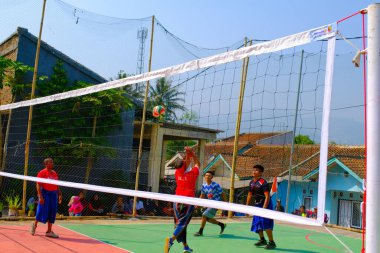 Bandung, Batı Cava, Endonezya - 17 Ağustos 2023: Bir grup orta yaşlı adam Endonezya 'nın 78. bağımsızlık günü, eğlenceli ve ferahlatıcı bir yarışma için voleybol müsabakası düzenliyorlar.