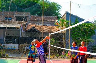 Bandung, Batı Cava, Endonezya - 17 Ağustos 2023: Bir grup orta yaşlı adam Endonezya 'nın 78. bağımsızlık günü, eğlenceli ve ferahlatıcı bir yarışma için voleybol müsabakası düzenliyorlar.