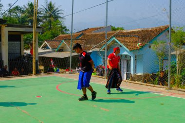 Bandung, Batı Cava, Endonezya - 17 Ağustos 2023: Bir grup orta yaşlı adam Endonezya 'nın 78. bağımsızlık günü, eğlenceli ve ferahlatıcı bir yarışma için voleybol müsabakası düzenliyorlar.