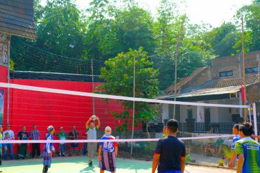 Bandung, Batı Cava, Endonezya - 17 Ağustos 2023: Bir grup orta yaşlı adam Endonezya 'nın 78. bağımsızlık günü, eğlenceli ve ferahlatıcı bir yarışma için voleybol müsabakası düzenliyorlar.