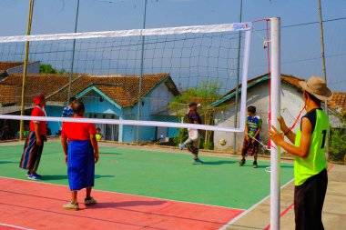 Bandung, Batı Java, Endonezya - 17 Ağustos 2023: Endonezya 'nın 78. bağımsızlık gününü anmak için orta yaşlı erkekler arasında voleybol müsabakası, eğlenceli ve ferahlatıcı bir yarışma.