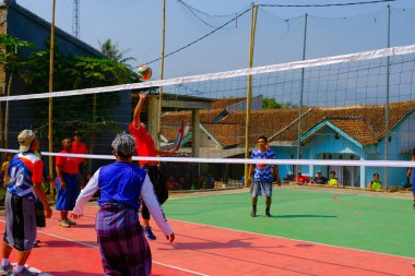 Bandung, Batı Java, Endonezya - 17 Ağustos 2023: Endonezya 'nın 78. bağımsızlık gününü anmak için orta yaşlı erkekler arasında voleybol müsabakası, eğlenceli ve ferahlatıcı bir yarışma.