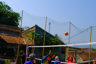 Bandung, Batı Java, Endonezya - 17 Ağustos 2023: Endonezya 'nın 78. bağımsızlık gününü anmak için orta yaşlı erkekler arasında voleybol müsabakası, eğlenceli ve ferahlatıcı bir yarışma.