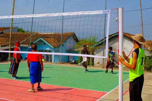 Bandung, Batı Java, Endonezya - 17 Ağustos 2023: Endonezya 'nın 78. bağımsızlık gününü anmak için orta yaşlı erkekler arasında voleybol müsabakası, eğlenceli ve ferahlatıcı bir yarışma.
