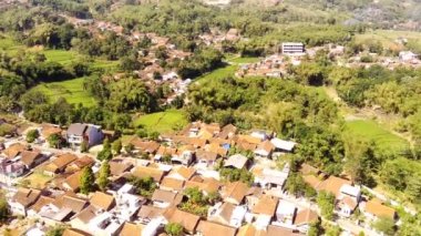 Şehrin banliyö bölgesinde, güneşli bir günde dağ manzaralı büyük konutlar. Kurak mevsimde, Bandung, Endonezya 'nın dışındaki kalabalık evlerin insansız hava aracı görüntüsü. 4K Görüntü