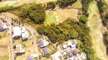 Golf sahaları ve seçkin evler. Seçkin konut kompleksi Bojong Koneng-Bandung, Endonezya 'yı çevreleyen çok geniş bir golf sahasının insansız hava aracı videosu. Hava Görüntüsü 4k Çözünürlüğü