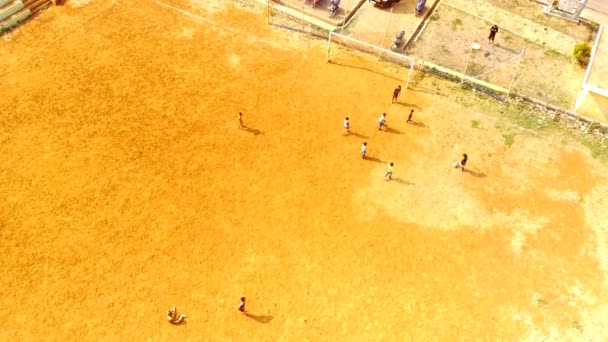 スポーツ フットボール 空中ランドスケープ 野外でボールを追いかけながら走り回っている子供たちのドローンビデオ 子供たちは朝サッカーをしている 4K解像度の飛行ドローンからの空中撮影 — ストック動画