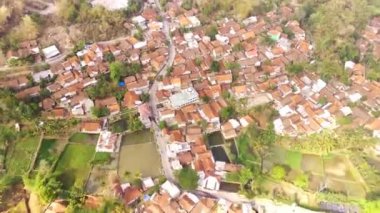 İnsansız hava aracı görüntüleri. Batı Java-Endonezya 'daki yoğun nüfuslu bir yerleşim ve pirinç tarlalarının havadan zaman atlaması. 4K çözünürlüğündeki bir insansız hava aracından havadan ateş edildi.