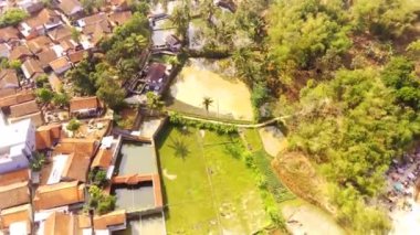 Drone Videoları. Hiper Lapse Görüntüleri. Majalaya kırsalının kuş bakışı görüntüsü. Yeşil pirinç tarlaları, yerleşim bölgeleri ve yerleşim yerleri var. Uçan bir drondan havadan ateş edilmiş. Endonezya 