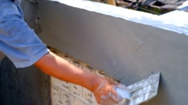 Endüstriyel Videografi. İnşaat İşleri. Video İnşaat çalışanları beton duvar dokusuna havan topu uygulamaya çalışıyor. Beton duvar dokusu üzerinde çalışan insan elini kapat. Endonezya