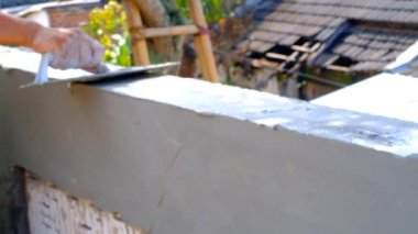 Endüstriyel Videografi. İnşaat İşleri. Video İnşaat çalışanları beton duvar dokusuna havan topu uygulamaya çalışıyor. Beton duvar dokusu üzerinde çalışan insan elini kapat. Endonezya