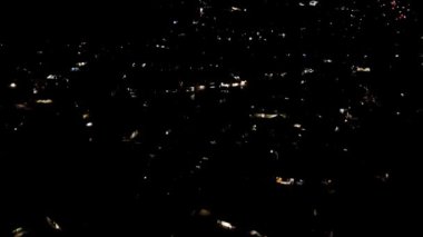 Video Dronlar. İHA 'nın gece uçuşu görüntüleri. Evin ışıkları gece parlıyor. 4K çözünürlüklü 30 fps ateşlendi.