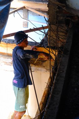 Bandung, Batı Java, Endonezya - 27 Aralık 2023: Sanayi Fotoğrafçılığı. Mavi gömlekli adam köşe yazısı yazıyor. Oyuncuları ve sütunu bir spatula kullanarak düzleştir.