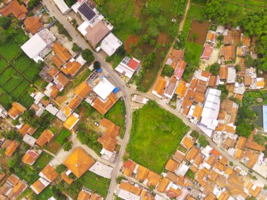 Batı Java Eyaleti, Endonezya 'nın başkenti Bandung City' deki evler ve pirinç tarlalarının havadan görüntüsü. Yoğun yerleşimlerin sıkıştırdığı pirinç tarlalarının manzarası. 200 metre yükseklikte uçan bir İHA tarafından vuruldu..
