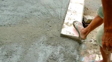 Koyu tenli bir işçinin eli ıslak zemine süpürgeyle vuruyor. Kaba bir döküm dokusu yaratmak için ıslak zemine çarpmak. 4K çözünürlükte 30 Fps.