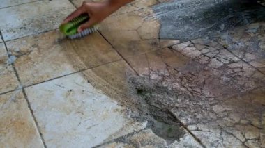 Ev yapımı videografi. Elle çekim. Kabuklu zemini fırçalayan ev işleri. Beton kaplı zemin temizleniyor. 4K çözünürlükte 30 Fps.