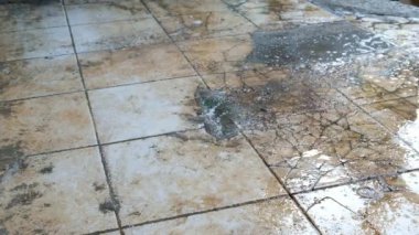 Ev yapımı videografi. Elle çekim. Ev işi bir süpürgeyle zemini süpürür. Beton kaplı zemin temizleniyor. 4K çözünürlükte 30 Fps.