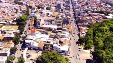 Bandung City 'deki Tegalega Parkı' nın kıyısındaki ana yolun hızlı çekimi. Parklar ve yoğun nüfuslu yerleşim bölgeleriyle çevrili yolun manzara görüntüsü. Drone Görüntüsü. Top View. Sinematik. 4K insansız hava aracından ateşlendi. 30 Fps çözünürlük.