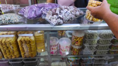 Camın arkasında çeşitli kek ve atıştırmalıklar var. Bayram sırasında dükkanlarda satılan desenli kek ve atıştırmalıklar. Endonezya kültürü. Özel bayram yemeği. Ramazan Kareem. Ramazan Bayramı