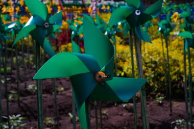 Eğlence parkında plastik yeşil fırıldak yakın plan. Lunaparktaki süs eşyalarının soyut arkaplanı. Grafik Kaynaklar. Makro Fotoğrafçılık. Seyahat belgesi. Tatil fotoğrafçılığı kavramı