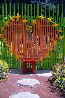 Parkın ortasında büyük bir kalp şeklinde fotoğraf kabini. Lunaparkı süsleyen süslemelerin arka planı. Grafik Kaynaklar. Arka plan fotoğrafçılığı. Seyahat Uçurumları