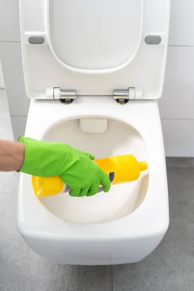 緑のゴム手袋の主婦手は消毒ジェルと洗面器で黄色のボトルを保持します トリミングされたショット 家事のコンセプト — ストック写真