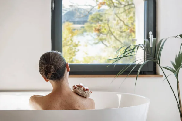 后视镜 女人在宾馆里洗热水澡 看窗户 用柔软的海绵洗她的身体 健美和日常美感的概念 女性在家泡温泉 — 图库照片