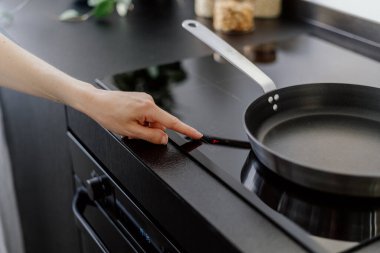 Kadın el dokunuşu sensör düğmesi kontrol paneli elektrik hob ve yemek pişirme ev mutfağı, modern ev aletleri 
