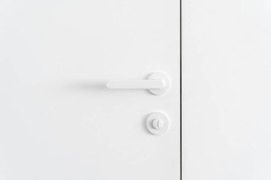 Alışveriş merkezinde umumi tuvaletin banyo kapısının üzerinde modern metal sapı var.