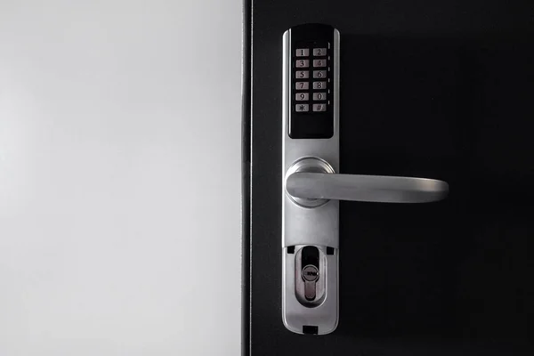 Door access control. Temporary digital code for opening the room. Close up view of self check in at hotel or apartment. Metal handle with keypad on smart security system against white copy space wall