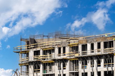 İnşaat endüstrisi ve inşaat geliştirme reklamları. Mavi gökyüzüne karşı duran yüksek katlı bir panelin ön cephesi. Gayrimenkul yatırımları kavramları