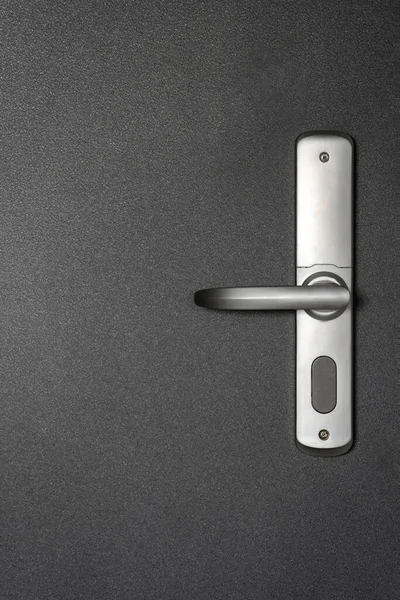 公寓黑色现代风格门上的金属把手垂直拍摄 在门把手处的非接触式元件系统的近景 安全设备 无钥匙打开大楼里的房间 — 图库照片