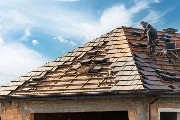屋根の上にグレーの金属タイルを設置し青い空の背景に木製のフレームを屋外に設置する工程 — ストック写真