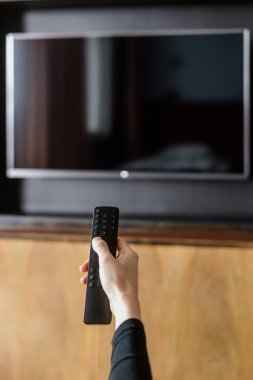 Uzaktan kumandalı kadın görüntüsünü kapat, TV 'yi açmak için düğmeye bas ve TV' yi aç. Oturma odasının duvarında kopya alanı olan şablon lcd görüntüsü