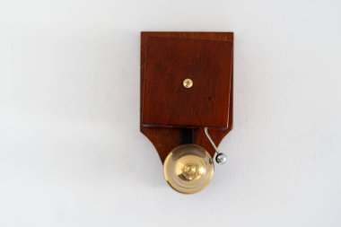 Binadaki beyaz fotokopi duvarında asılı olan eski ahşap kapı zilinin sesini yakından izleyin. Modern apartmanda klasik stil tasarım ögesi