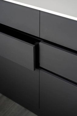 Çağdaş dairede çekmeceleri olan koyu gri ahşap gardırop, depolama konsepti