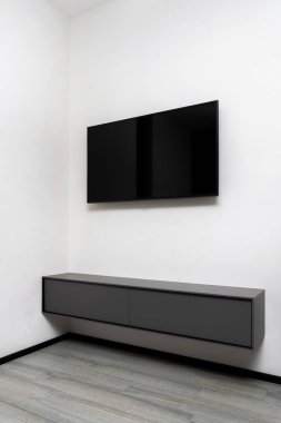Modern gri büfe ve televizyon ekranı oturma odasının duvarında asılı, çağdaş iç mekan, ev elektroniği konsepti