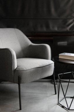 rahat koltuklar ve tekstil döşemeleri ve modern tarzda metal sehpa üzerine kitap modern iç dekorasyonlu bir dairede dinlenme odasında.