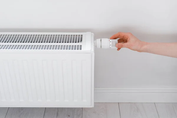 リビングのラジエーター温度を調節する女性の手家庭の快適暖房エネルギー効率経済概念 — ストック写真