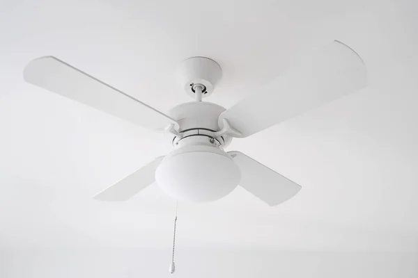 ceiling fan and lamp with switch on white background, room cooling and ventilation concept, detail in interior at apartment