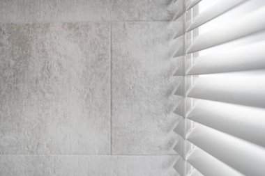 Banyodaki pencerelerde güneş ışığı ve gizlilik koruması kavramı. Beyaz panjurların yan görünüşü, geleneksel Venedik tarzında tahta çatallarla kör ediyor. Çatı katındaki gri duvardaki alanı kopyala