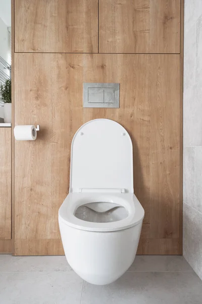 前景白色陶瓷Wc碗与开放盖在豪华浴室内部 有隐藏蓄水池和墙壁的公寓式厕所 — 图库照片