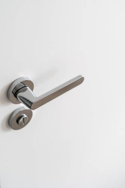 Yüksek açılı alüminyum kapı tokmağı ve beyaz kapıya kilitlenmiş. Gizlilik ve koruma kavramı. Modern odanın iç tasarımı. Boşluğu kopyala
