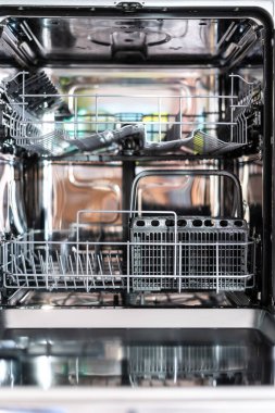 Tabaklar için metal raflı, çatal bıçak takımı için konteynır olan boş modern bulaşık makinesine yakından bakın. Mutfakta ev işi. Su kaynağını, enerji tasarruflu aygıt kavramını kaydet.