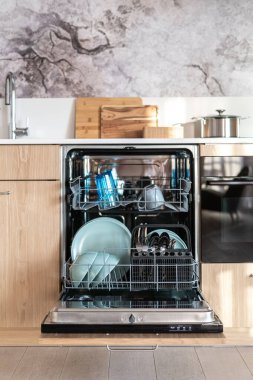 Rafları açık bulaşık makinesinin ön manzarası. Temiz, kuru mavi tabaklar, kupalar, kaşıklar ve çatallar. Kullanımı kolay modern mutfak. Su ve enerji tasarruflu ev aletleri kavramından tasarruf et