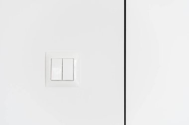 Modern apartmanda beyaz arka planda çağdaş plastik düğmelere ön görünüm, elektrik kavramından tasarruf